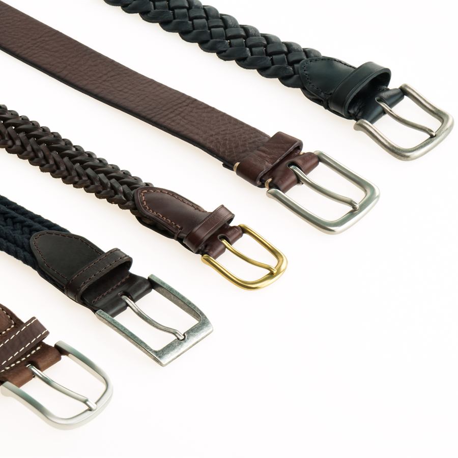 A row of belts with metal buckles, including braided brown and black leather belts